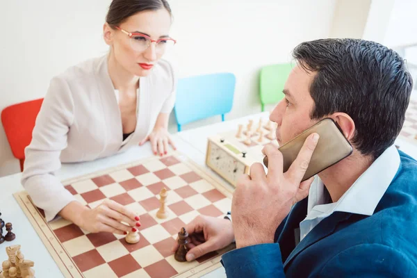 Uomini d'affari che giocano a scacchi con l'uomo al telefono — Foto Stock