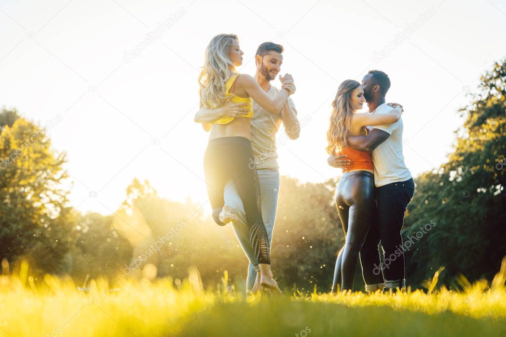 Group of people dancing Kizomba in sunset