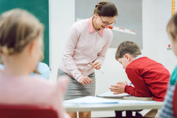 Kobieta nauczyciel mówi do uczniów w klasie — Zdjęcie stockowe