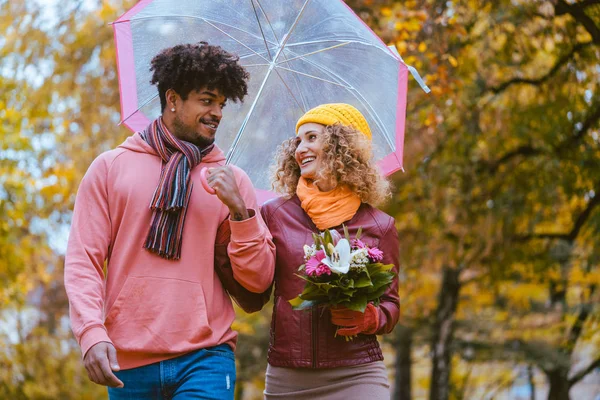 Couple with different ethnicities having a autumn walk in the park