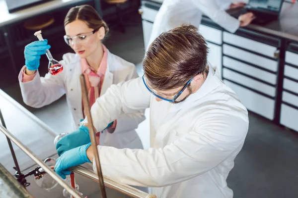 Ученые работают в лаборатории над новым химическим соединением — стоковое фото