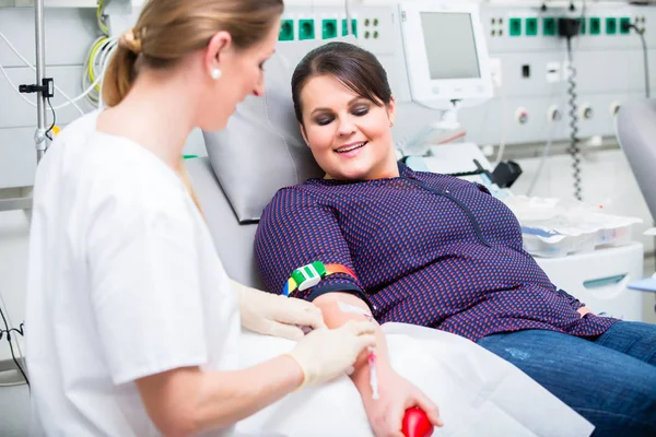 Assistente de médicos verificando o acesso de doador de sangue feminino — Fotografia de Stock
