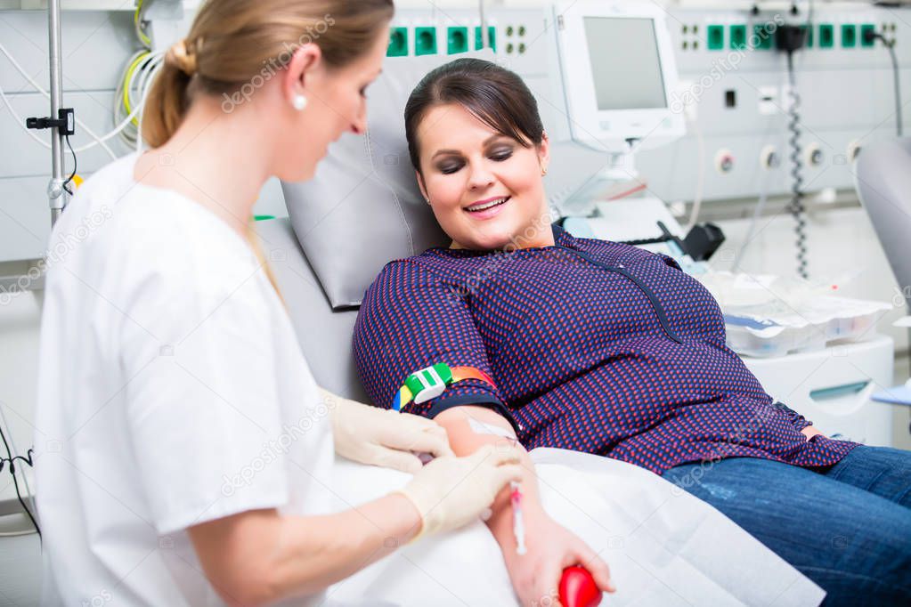 Doctors assistant checking access of female blood giver