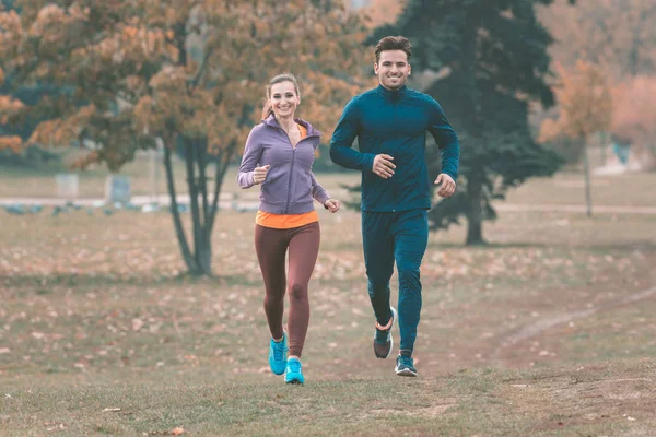 Couple in wonderful fall landscape running for better fitness — Stock Photo, Image