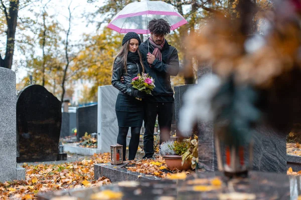 Pár gyász elhunyt szeretett egy temetőben ősszel — Stock Fotó