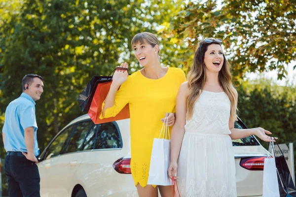 Frauen mit Einkaufstüten steigen aus Taxi — Stockfoto