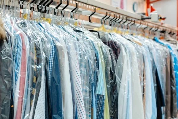 Carousel of clothing waiting for pick-up in dry cleaning shop — Stock Photo, Image