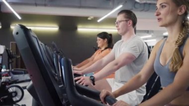 Eğitmenleri ile fitness bisikleti üzerinde insanlar