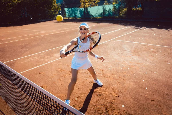 Γυναίκα χτυπάει την μπάλα του τένις στο γήπεδο — Φωτογραφία Αρχείου