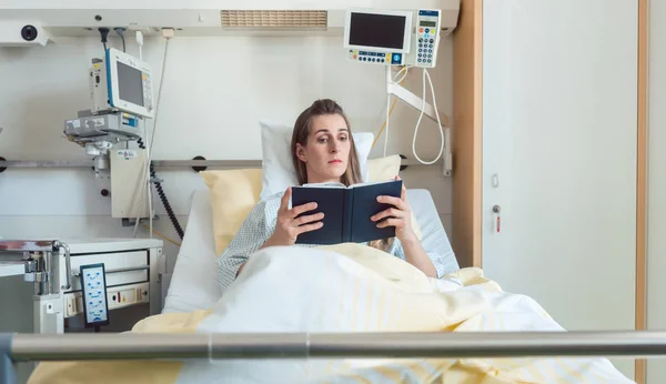 Wanita di tempat tidur rumah sakit membaca Alkitab — Stok Foto