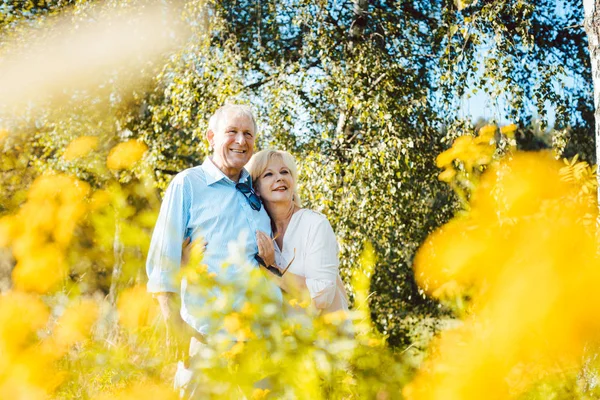 Старшие муж и жена наслаждаются жизнью на цветущем лугу — стоковое фото