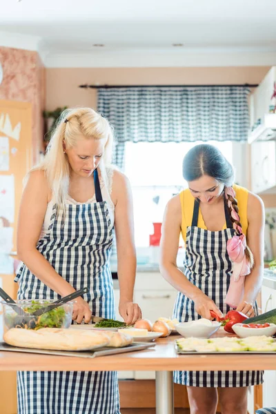 Duas mulheres preparando pratos na cozinha — Fotografia de Stock