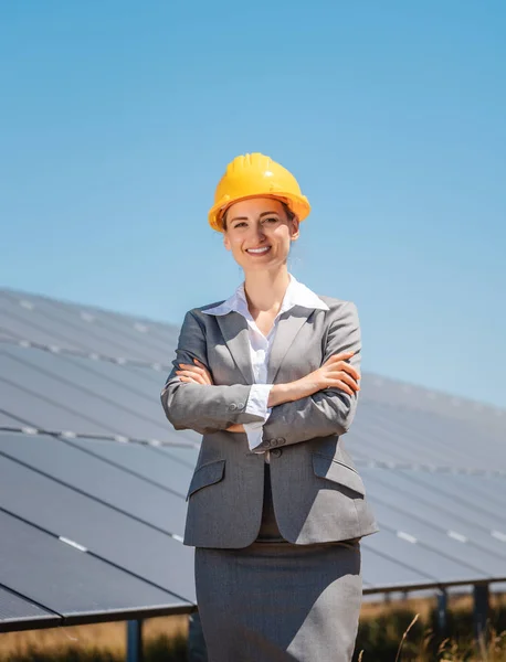 Mulher investidora em energia limpa em pé na frente de painéis solares — Fotografia de Stock