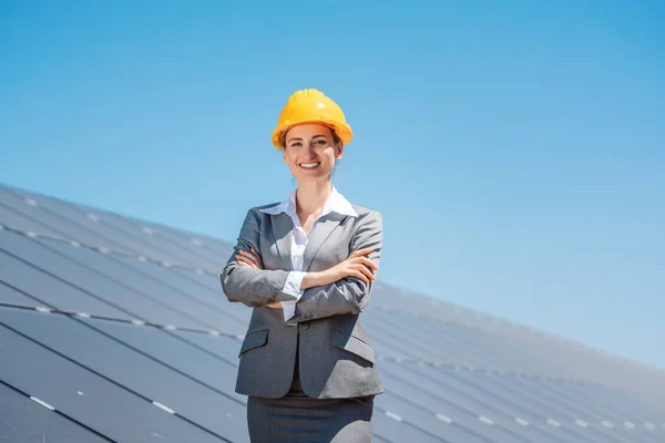 Mulher investidora em energia limpa em pé na frente de painéis solares — Fotografia de Stock