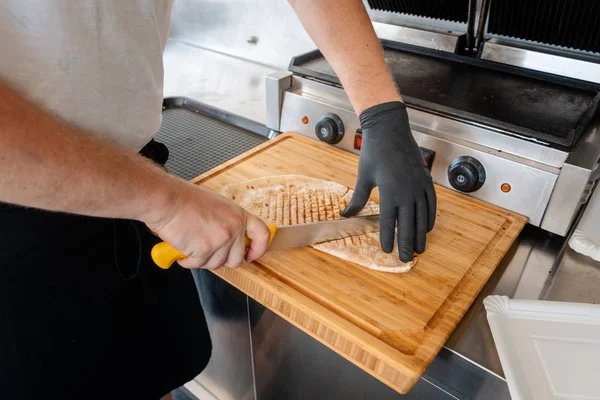 Chef cutting Mexican taco on wooden board — Stock Photo, Image