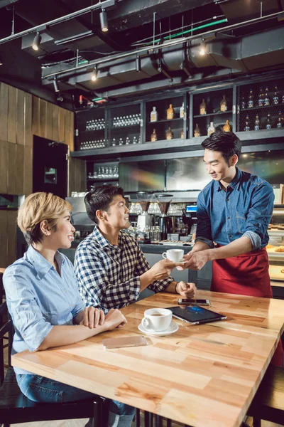 Servitör servering kaffe i caféet — Stockfoto