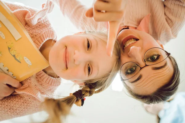 Teacher and schoolgirl making funny faces