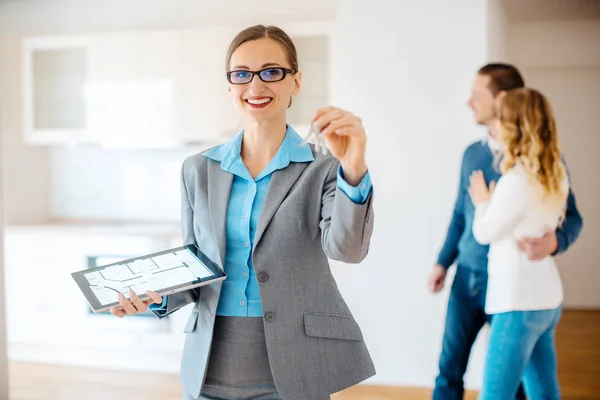 Wohnungsmakler mit Schlüssel und Grundriss des neuen Hauses — Stockfoto