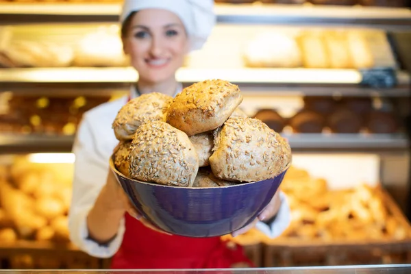Pane fresco presentato da una giovane donna di vendita attraente in panetteria — Foto Stock