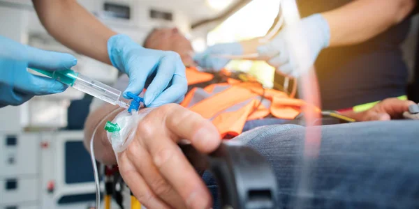 Akutläkare som administrerar injektionsnålen i ambulans — Stockfoto