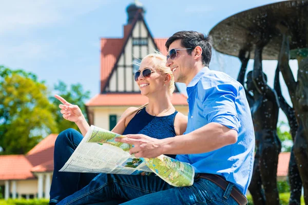 Smiling couple holding map — Stok Foto