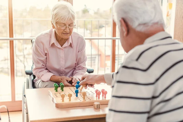 Δύο ηλικιωμένοι σε ένα γηροκομείο παίζοντας ένα επιτραπέζιο παιχνίδι — Φωτογραφία Αρχείου