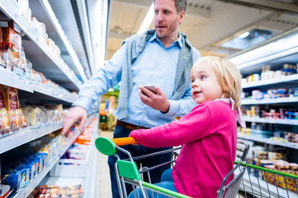 スーパー マーケットの新鮮な部門の彼の子供を持つ男 — ストック写真