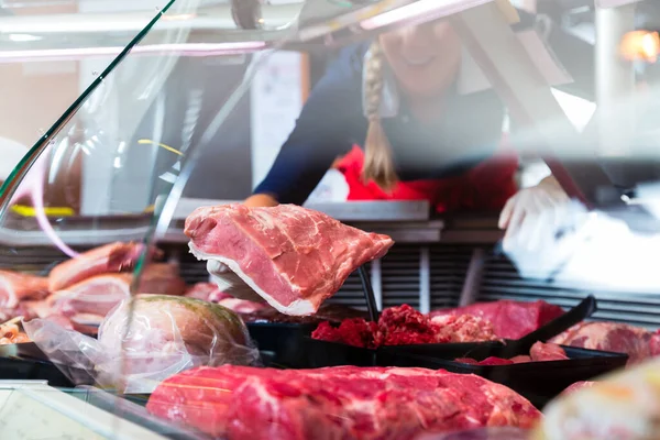 Maso v butcher shop displej do prodeje žena — Stock fotografie