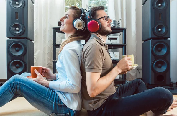 Пара з навушниками насолоджується музикою зі стереосистеми Hi-Fi — стокове фото