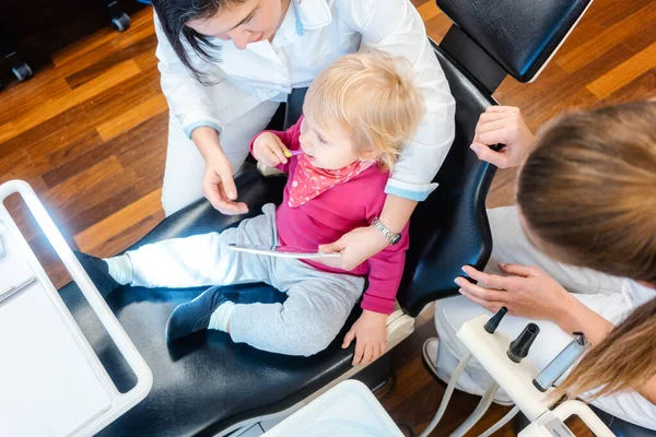 Klein kind kijken in spiegel wordt behandeld door de tandarts — Stockfoto