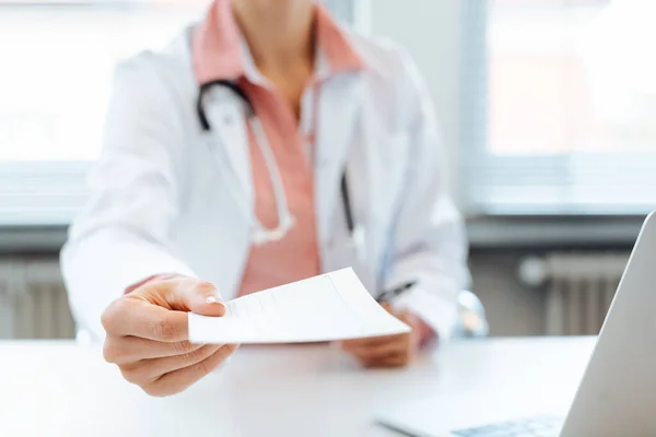 Médico segurando papel de prescrição na câmera — Fotografia de Stock