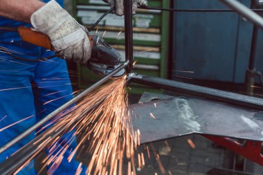 İşlenecek parçanın kıvılcım uçan taşlama metal fabrika işçisi