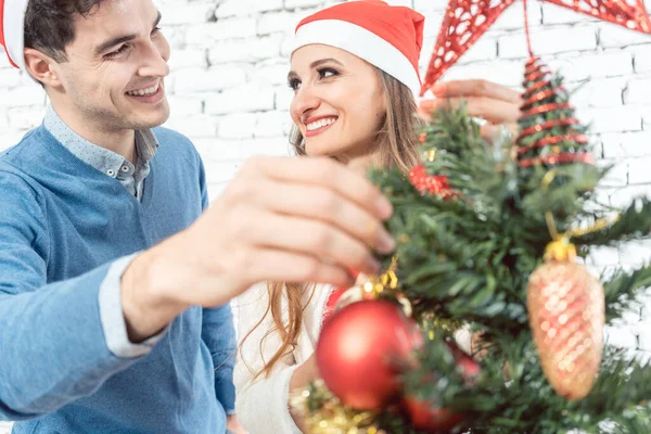 Hombre poniendo adorno de Navidad en el árbol — Foto de Stock