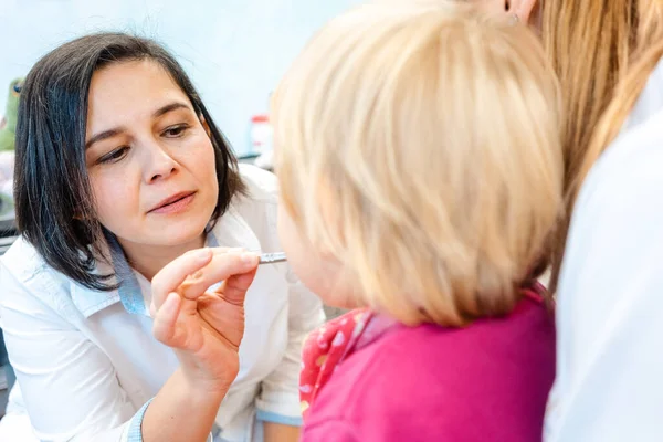 Kleines Kind sieht im Spiegel zu, wie es vom Zahnarzt behandelt wird — Stockfoto