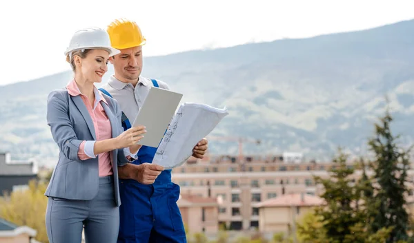 Vastgoedontwikkelaar en bouwvakker die project samen creëert — Stockfoto