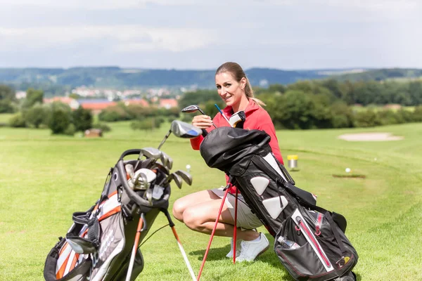Golfista feminina segurando clube de saco — Fotografia de Stock