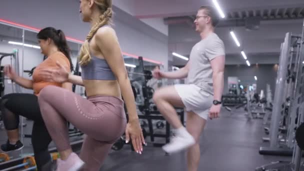 Grupo de personas en forma en el gimnasio haciendo aeróbic paso — Vídeo de stock