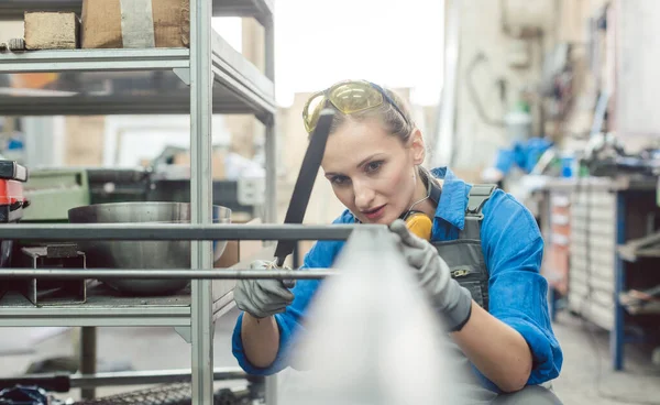 Mujer metalúrgica comprobando la exactitud de su trabajo — Foto de Stock