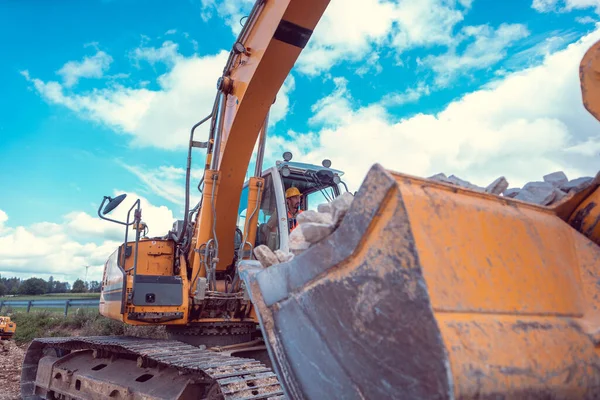 Trabalhador da construção que opera a escavadora de esteiras rolantes — Fotografia de Stock