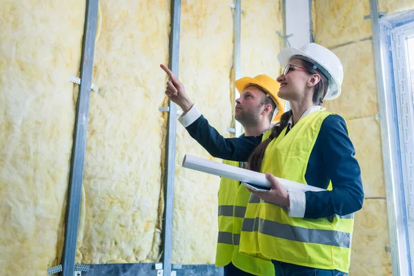 Gerente de construcción y arquitecto revisando los trabajos de aislamiento — Foto de Stock