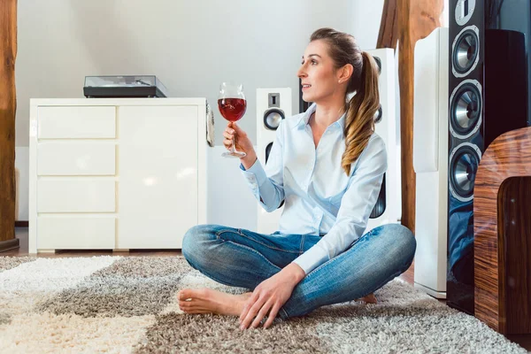 Kvinna med glas vin framför Hi-Fi-högtalare — Stockfoto