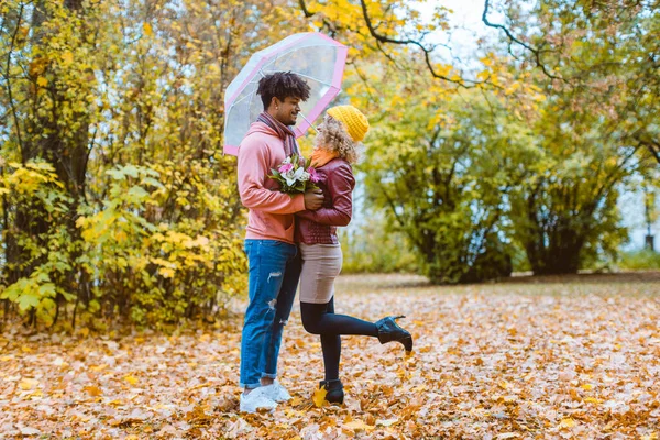 Uomo e donna di diversa etnia che si abbracciano in autunno — Foto Stock