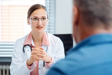 Ofisinde erkek hasta ile güzel doktor