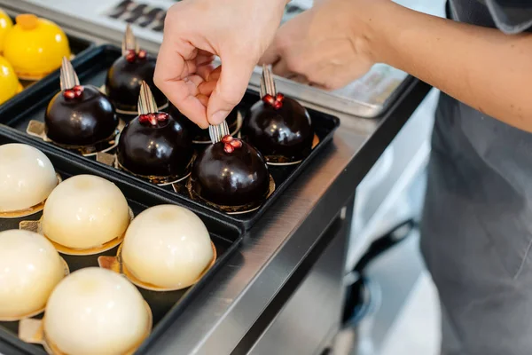 Patissiê trabalhando em pequenas sobremesas de chocolate — Fotografia de Stock