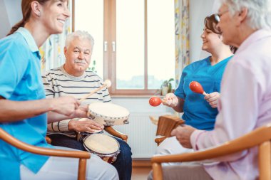 Seniors in nursing home making music with rhythm instruments clipart
