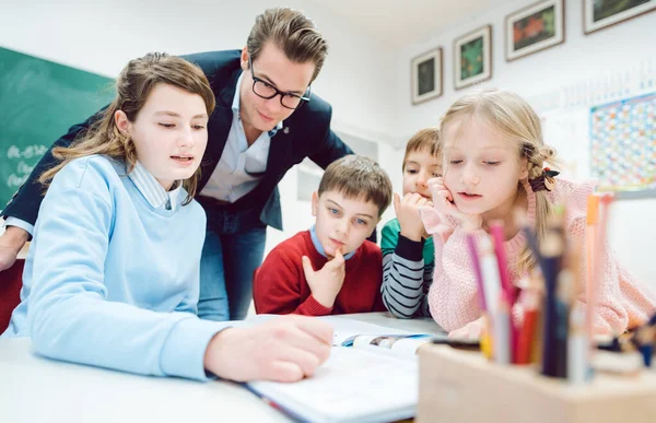 Team session i skoleklassen med alle elever, der arbejder sammen - Stock-foto