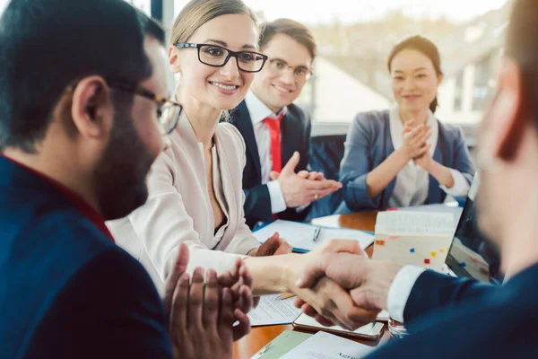 Team van zakenmensen die onderhandelen over een overeenkomst die de deal sluit — Stockfoto