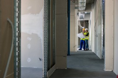 İnşaat alanını inceleyen planlı bir inşaatçı