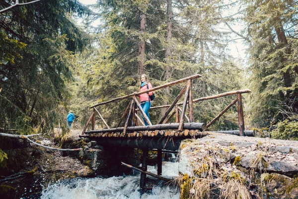 Frau auf Wanderung auf Brücke im Wald — Stockfoto