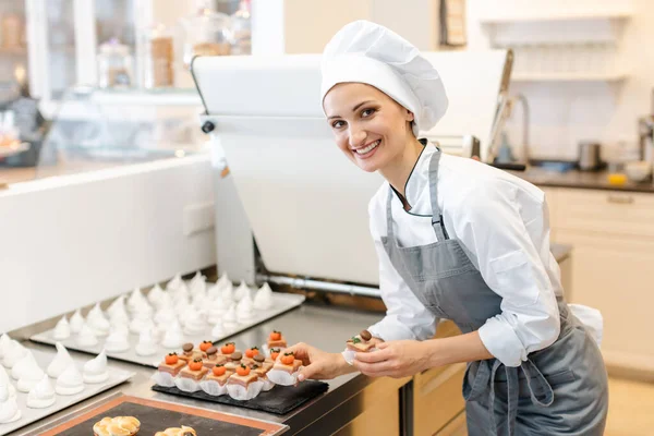 Paitssier putting petite fours on a sheet — Stock Photo, Image